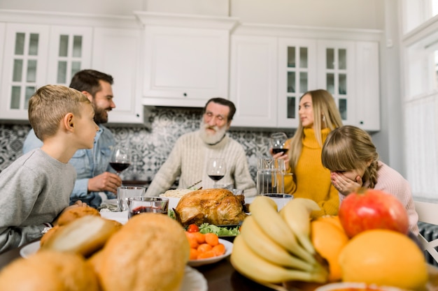 Familie zitten aan de tafel en vakantie vieren. Grootvader, ouders en kinderen. Traditioneel diner. Focus op de kalkoen