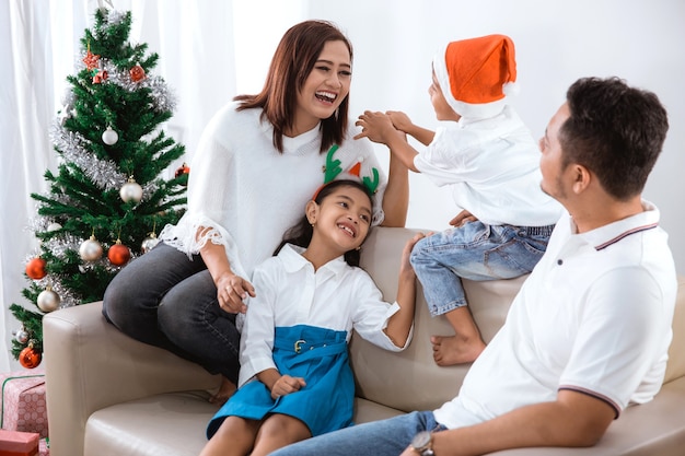 Familie zittend op een bank en samen spelen op eerste kerstdag