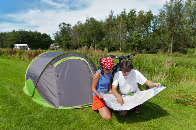 Familie zomervakantie op de camping. Gelukkig glimlachend actief paar in tent.