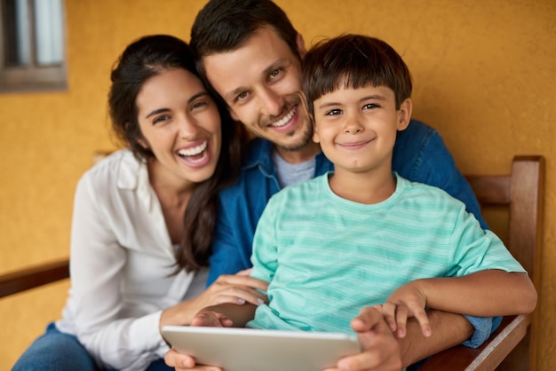 Familieband Portret van een mooi jong stel en hun zoon die samen thuis een digitale tablet gebruiken