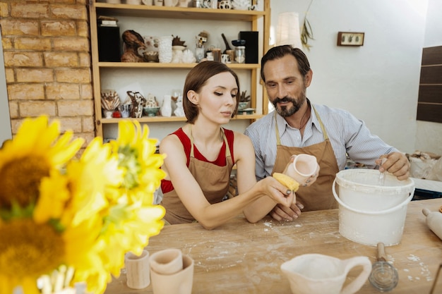 Familiebedrijf. een stel professionele pottenbakkers die zich enthousiast en succesvol voelen bij het opstarten van hun familiebedrijf