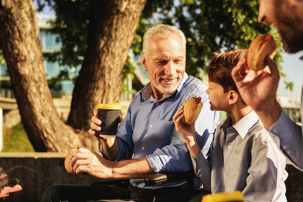 Familiebijeenkomst Zoon en kleinzoon zitten op bankje