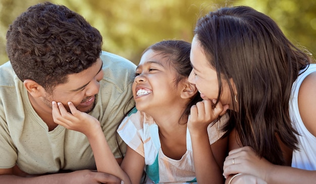 Familiebinding en liefdesglimlach van een moeder, vader en meisje samen buiten die geluk in de natuur tonen Gelukkige moeder, vader en jong kind voelen zich gelukkig en ouders zorgen in een zomers kinderpark glimlachend