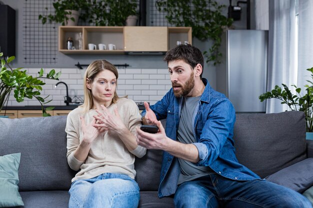 Familieconflict thuis Een boze man vermoedt dat een vrouw van verraad schreeuwt tegen haar eisen uitleg toont de telefoonberichten