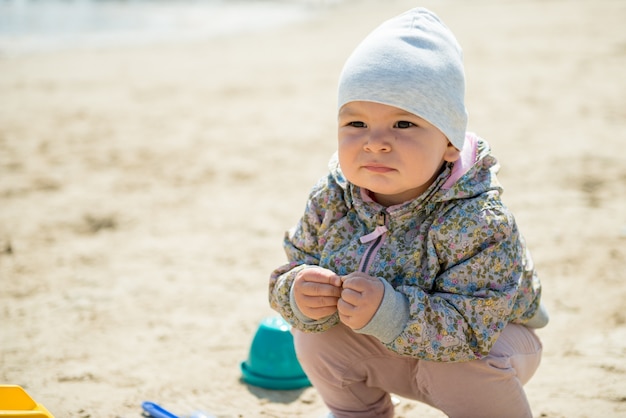 Familiedag in het park. Gelukkig jong koppel met pasgeboren baby. Moeder draagt baby in ergonomische draagzak