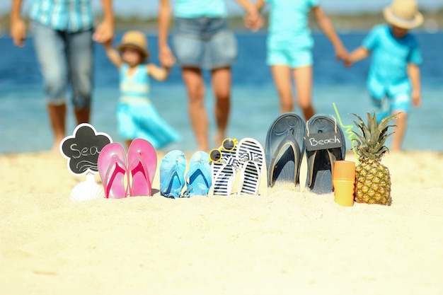 Familiepantoffels op het zand op het strand in de zomer