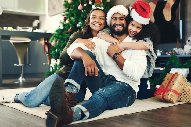 Familieportret kerstcadeau en liefde in vakantieviering gelukkige glimlach en ontspannen op vloerdecoratie en thuis Moeder vader en meisje vieren feestelijk geluk en knuffel thuis in brazilië