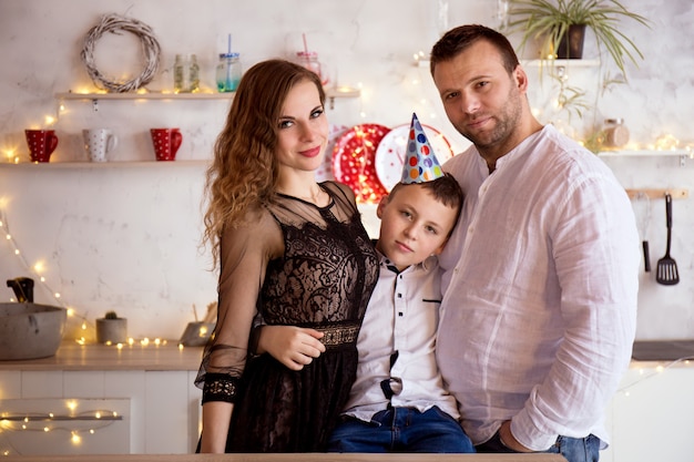 Familieportret op de verjaardag van zoon in de keuken