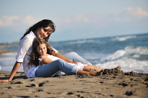 familieportret van jonge mooie moeder en dochter op het strand