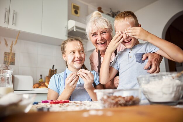 Familieportret van oma en kleinkinderen tijdens het maken van koekjes