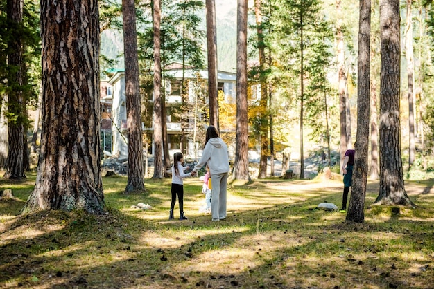 Familiereizen in Europa Vrouwelijke reiziger met kinderen tussen de natuur en pijnbomen