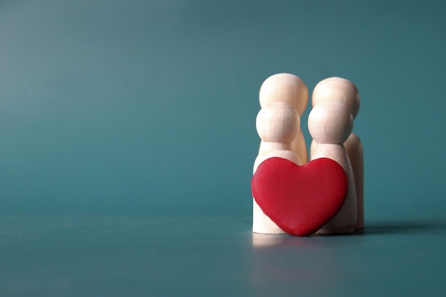 Familierelatie en liefdesconcept Houten poppen en rode hartvorm met kopieerruimte