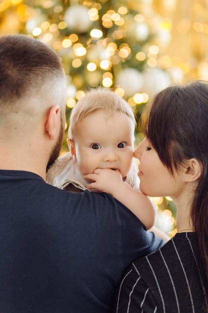 Families Portrait Of Happy Young Mother And Father with Child Posing In home Interior