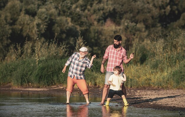 Familiespel van steen die drie generaties familie overslaat, vader, zoon en grootvader die samen ontspannen