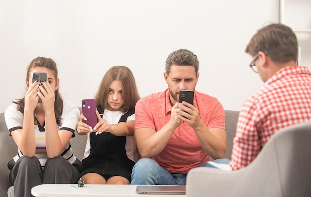 Foto familietherapie ouders met kind praten met maatschappelijk werker telefoonverslaafde moeder vader en dochter levensverzekering en adoptie ouderleraar ontmoet vader moeder en kind tijdens psychiatersessie