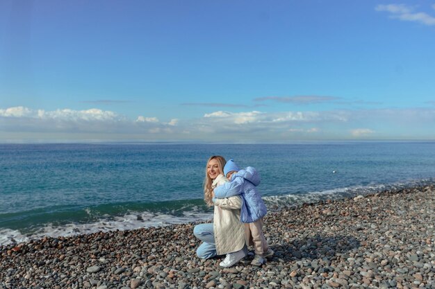 Familievakantie op zee in de herfst of lente Gelukkige familie moeder en dochter op een wandeling langs de kust