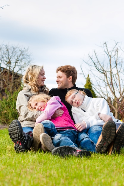 Familiezitting samen op een weide in de lente