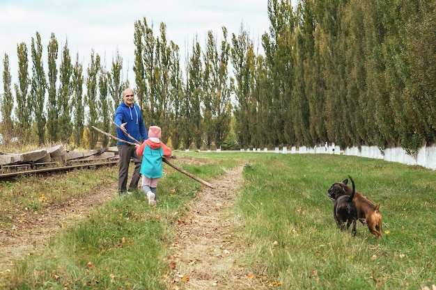 family on an active autumn walk with their four-legged dog friends