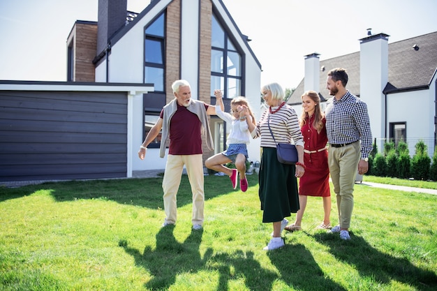 family activities. active grandpa looking at his granddaughter while walking together