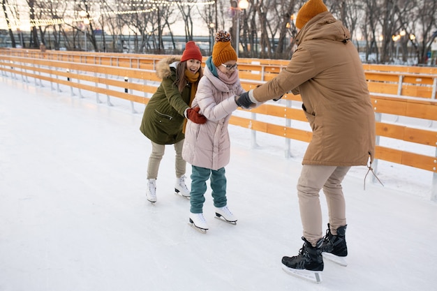 公園のアイススケートリンクで楽しんでいる冬休みの家族の活動