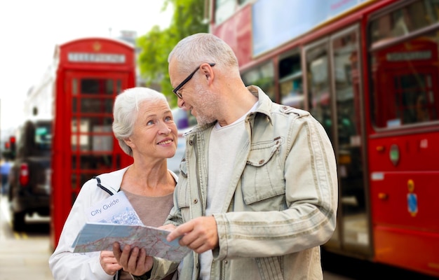 Концепция семьи, возраста, туризма, путешествий и людей - пожилая пара с картой на фоне улицы лондонского города