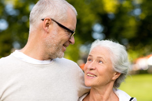 family, age, tourism, travel and people concept - senior couple hugging in city park