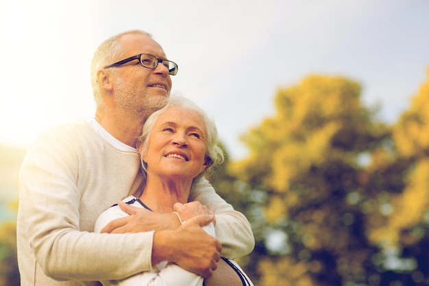 family, age, tourism, travel and people concept - senior couple hugging in park