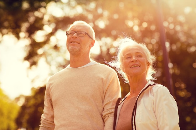 Concetto di famiglia, età, turismo, viaggi e persone - coppia senior nel parco