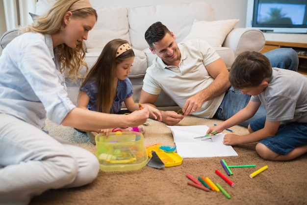 Foto famiglia che assiste il ragazzo nel disegno