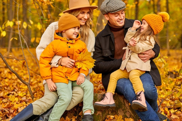 Famiglia in autunno parco circondato da foglie