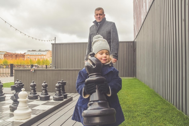 家族の赤ちゃんのお父さんお母さん遊び場はチェスの外で秋を遊ぶ