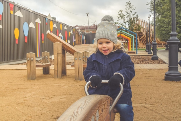 La famiglia bambino papà mamma parco giochi gioca in autunno