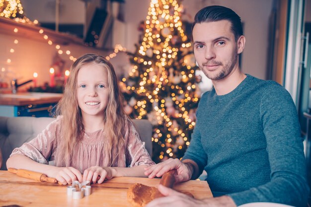 Biscotti di pan di zenzero di cottura della famiglia sulla vacanza di natale