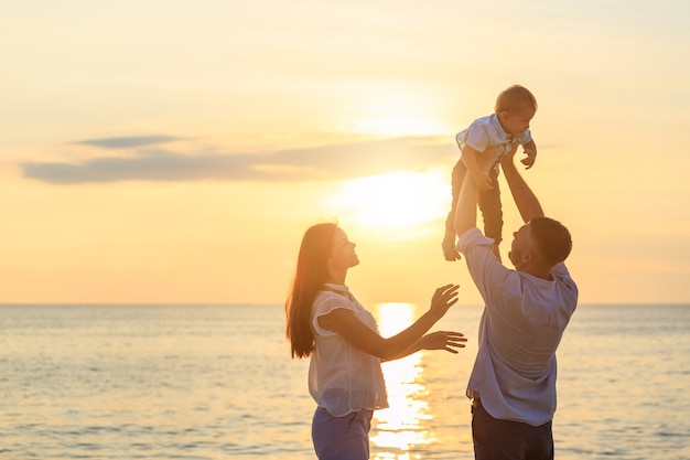 Family on the beach concept, Father playing and carrying his son on the tropical beach