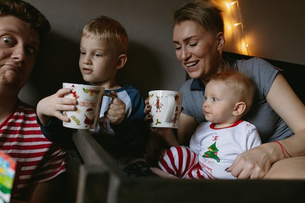 Photo family before christmas at home drinking hot chocolate with marshmallows