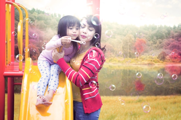 Family blowing soap bubble on slide