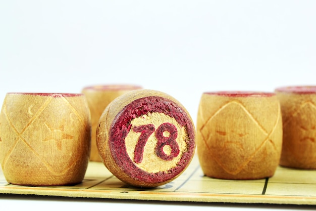 Family board game Lotto. Wooden barrels loto numbered 78 on a white background.