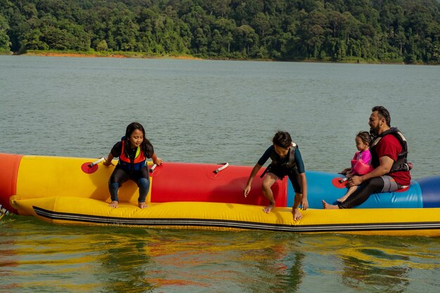 Photo family on boat in lake against trees