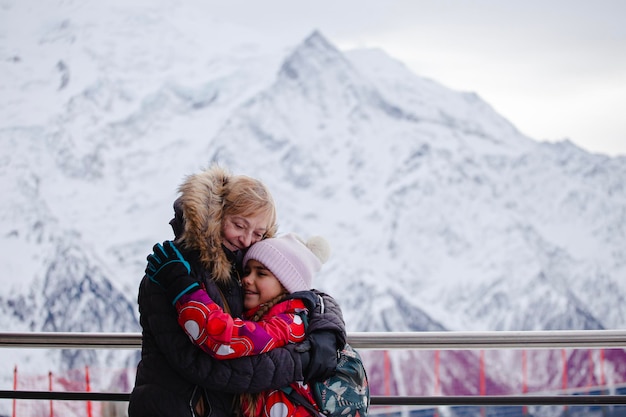 アルプス山脈で家族の結びつき 高齢の女性が子供を抱きしめる 家族の結びつけ 積極的な休暇