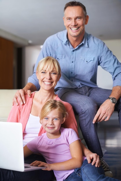 Family bonding Een gezin van drie met een laptop in de lounge