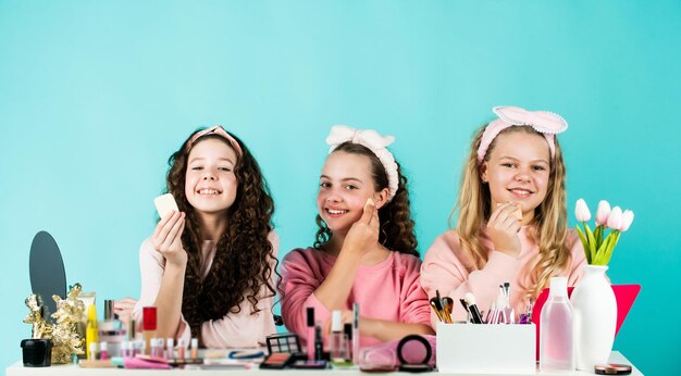 Family bonding time childhood happiness retro kids put on makeup skin care cosmetics for children beauty and fashion three happy girls at hairdresser friendship and sisterhood Fashion concept
