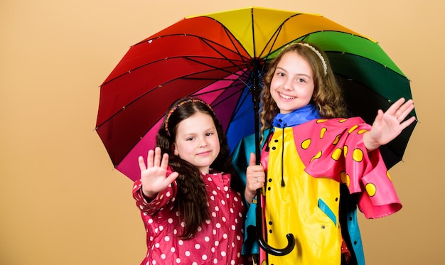 가족 유대 비옷을 입은 어린 소녀 화려한 우산을 가진 행복한 어린 소녀 비 보호 무지개 가을 패션 쾌활한 힙 스터 어린이 자매애 더 이상 비가 내리지 않습니다.