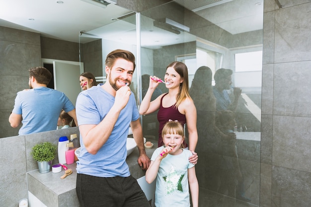 Family brushing teeth in bathroom