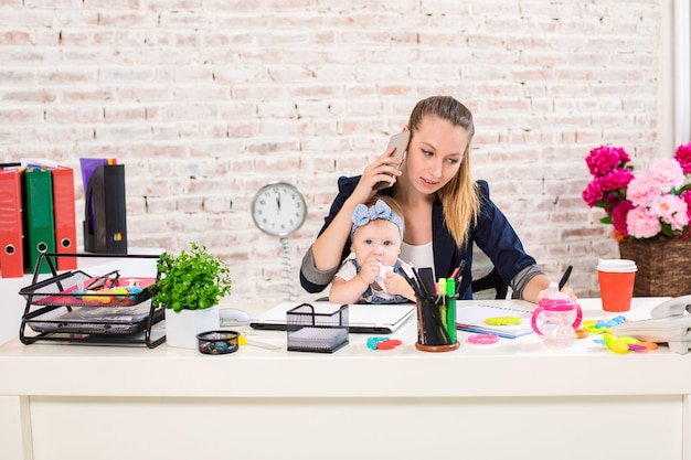 Family business  telecommute businesswoman and mother with kid is making a phone call