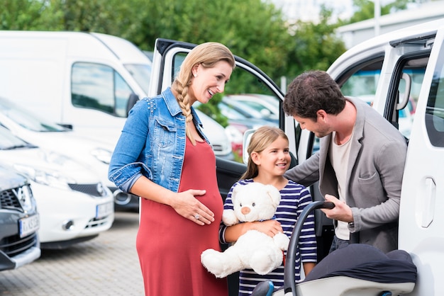 家族がディーラーで車、母親、父親と子供を買う