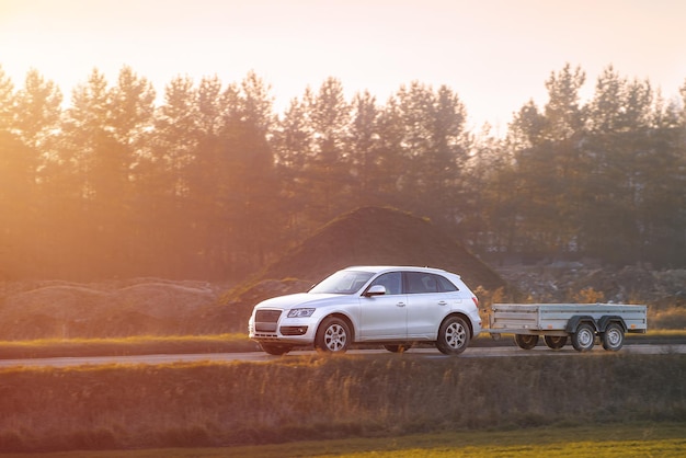 Family car with trailer driving on sunny day