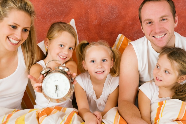 Family and cat having breakfast in bed