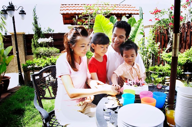 Photo family celebrating birthday in lawn