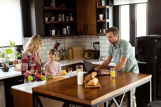 Photo family chatting and preparing food around a bustling kitchen counter filled with fresh ingredients and cooking utensils