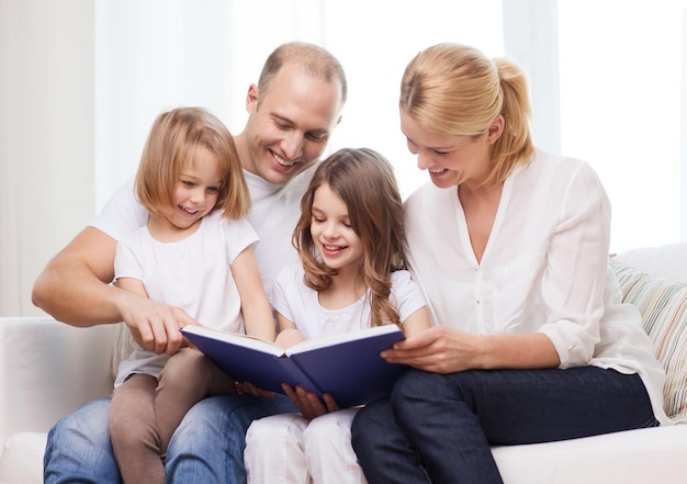 Photo family, child and home concept - smiling family and two little girls with book at home